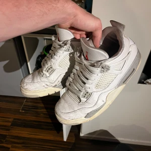 Nike Air Jordan 4 Retro Vit/Grå - Säljer ett par Nike Air Jordan 4 Retro white Oreo storlek 44! Cond 5/10, går att fräscha upp och fina till de, inga större skador utan bara yttre lagret färg på vissa ställen och creasade. Runt 6000 nypris på dessa! Riktig feta skor om man putsar upp de!