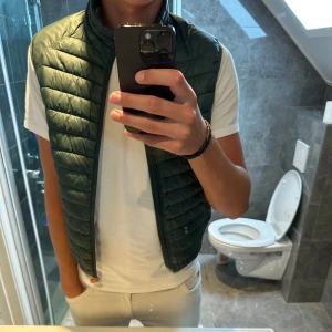 Mörkgrön dunväst från Save The Duck - Säljer en snygg mörkgrön dunväst från Save The Duck. Dock är dragkedjan sönder men går att fixa hos en skräddare. Annars en schysst väst