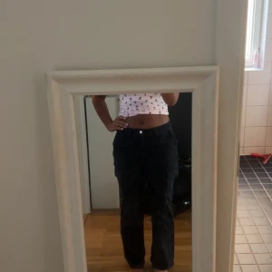 Svarta cargopants med raka ben - Säljer ett par svarta cargopants med raka ben och fickor på sidorna. Byxorna har normal passform och midja, perfekta för en chill och trendig look. Materialet känns slitstarkt och passar till många olika outfits.