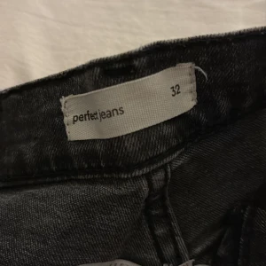 Svarta bootcut jeans från Perfect Jeans - Säljer ett par svarta bootcut jeans från Perfect Jeans i storlek 32. Jeansen har klassisk femficksdesign, normal passform och är tillverkade i ett mjukt denimtyg. Perfekta för dig som gillar en tidlös look med lite extra vidd nertill.