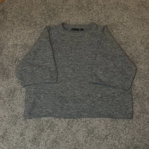 Stickad grå tröja - Grå stickad tröja ifrån lager 157. Säljes på grund av att den inte kommer till användning längre. Köpt ny för 150kr. Obs mellan långa ärmar!