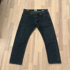 Jack&jones mörkblåa jeans - Jack&jones jeans i mörkblå tvätt med raka ben och femficksdesign. Jeansen har normal passform och är tillverkade i slitstarkt bomullsjeans. Perfekta för dig som gillar en tidlös look och vill ha ett par jeans som funkar till allt.