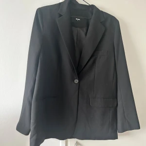 Svart kavaj från Bik Bok, stl S - Klassisk svart kavaj från Bik Bok i storlek S. Enkelknäppt med en knapp framtill och två fickor. Snyggt skräddad och helfodrad insida.