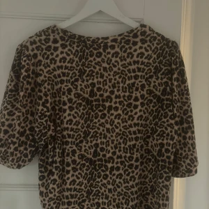Leopardmönstrad blus  - Snygg blus med leopardmönster och puffiga korta ärmar. Blusen har rund halsringning och är i mjukt material som känns skönt mot huden. Vet inte storlek men tror M!