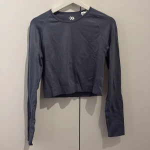 Mörkblå långärmad träningstopp - Snygg mörkblå långärmad träningstopp från Lager med croppad passform.