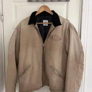 Beige jeansjacka från Bershka - Säljer en beige jeansjacka från Bershka med svart krage i manchester. Jackan har dragkedja framtill, tre fickor och quiltat foder på insidan. Perfekt för dig som gillar en avslappnad och stilren look. Storlek M, passar L också. Använd några få gånger.