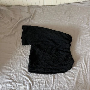 Svart offshoulder spets topp - Säljer en svart offshoulder topp med snyggt spetsmönster. Toppen är croppad och har en figurnära passform som framhäver siluetten. Ingen lapp då jag köpte begagnat