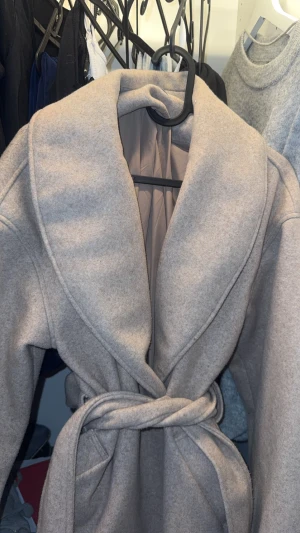 Beige kappa  - Jätte snygg beige kappa från ginatricot, använd max 4 gånger. Materialet är mjukt och känns lyxigt, band som man kan knyta för att få en snatched midja, varm och perfekt för hösten,vintern och våren. Pris kan diskuteras vid snabb affär. Osäker om den säljs längre 