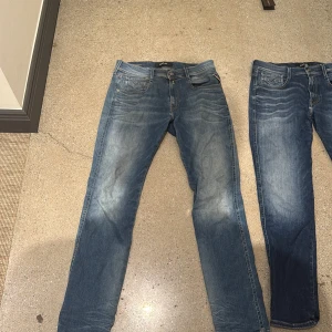Replay Anbass hyperflex - Säljer ett par klassiska blå jeansbyxor från Replay med snyggt slitna detaljer och raka ben. Jeansen har fem fickor, normal passform och är tillverkade i bomull med en skön jeanskänsla. Perfekta för en avslappnad stil. FLER BILDER BIFOGAS I DM