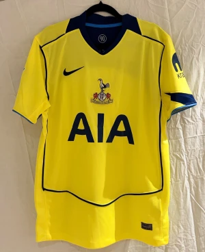 Tottenham tredjeställ 25/26 Xavi #7 -  Tottenham Hotspurs tredjetröja för årets säsong  med Carabao Cup och EFL patch på ärmen. Klassisk tupp-logga och mörkblå Nike swoosh på bröstet. Tillverkad i Dri-FIT polyester för skön känsla och bra ventilation. Snygg V-ringad krage i mörkblått.