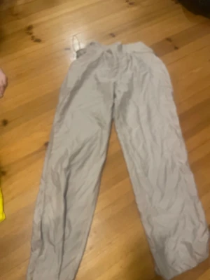 Beiga byxor från Kaffe, storlek M - Lätta och luftiga beiga byxor från Kaffe i storlek M. Byxorna har resår i midjan för extra komfort och är tillverkade i ett tunt, mjukt material som ger en avslappnad look. Perfekta för dig som gillar en enkel och stilren stil.