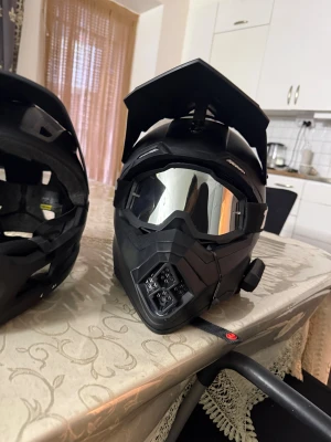 Svart motocrosshjälm med visir och goggles - Säljer en svart motocrosshjälm med coolt vinklat visir och matchande spegelgoggles från 100%. Hjälmen har en robust design med ventiler och detaljer i matt svart plast. Perfekt för dig som gillar att köra cross eller enduro och vill ha en snygg look. Den andra är cykelhjälm crosshjälmen köptes för 1000 kr ger båda för 1000kr crosshjälmen har bluetooth headset. Hjälmen är i bra skick