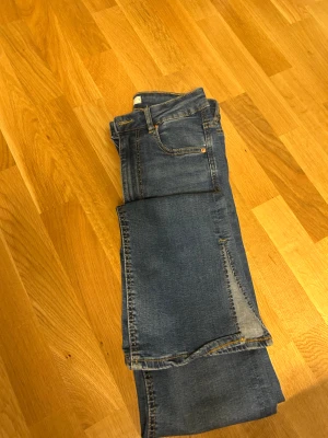 Blåa jeans från Gina Tricot S - Säljer ett par klassiska utsvängda blå Molly jeans med slits på sidorna från Gina Tricot i storlek S. Jeansen har en smal passform, hög midja och är tillverkade i stretchigt denim. Aldrig använda 