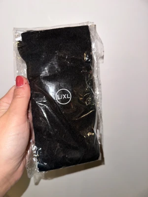 Svarta strumpor L/XL Svarta stödstrumpor - Ett par svarta benvärmare i storlek L/XL, fortfarande i sin originalförpackning. Svarta stödstrumpor är det perfekta valet för dig som vill kombinera komfort, stil och bättre blodcirkulation. De hjälper till att minska svullnad och trötthet i benen, oavsett om du står, går eller sitter mycket under dagen. Den stilrena svarta färgen gör dem enkla att matcha med alla outfits – diskreta, eleganta och funktionella. Investera i ett par som ger benen den support de förtjänar!