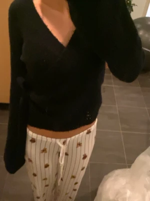 Marinblå omlottkofta från Gina Tricot - Mysig svart omlottkofta från Gina Tricot i ullblandning. Tröjan har lång ärm, knyt i sidan och en djup v-ringning.