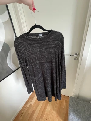 Svart/grå randig långärmad klänning  - Mysig svart/grå klänning från H&M med tunna grå ränder. Klänningen har lång ärm och en avslappnad passform