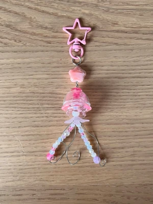 Rosa manet-nyckelring med pärlor 🪼🩷 - 🩷En manet som kan följa med på din resa! ⋅˚₊‧ ଳ⋆.ೃ࿔*:･  Maneten har glas komponenter så var försiktig! <3  Skriv i DM först, tack! ༊彡