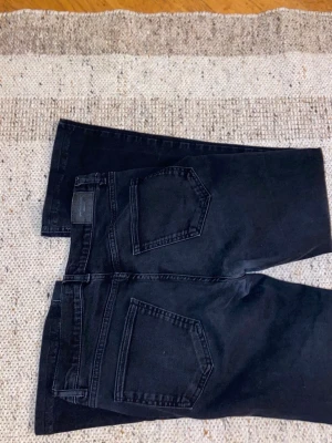 Svarta bootcut jeans från Perfect Jeans - Säljer ett par svarta bootcut jeans från Perfect Jeans i storlek 40. Jeansen har klassisk femficksdesign, kopparfärgade nitar och normalhög midja. Materialet är stretchigt jeans-tyg som sitter snyggt och bekvämt. Perfekta för dig som gillar en tidlös look. Bra för priset 