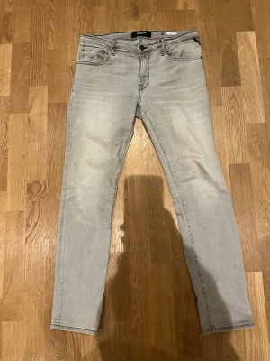 Replay jeans storlek 30 - Säljer ett par ljusgrå jeans från Replay i storlek 30. De har klassisk femficksdesign, smal passform och är tillverkade i mjukt jeanstyg. Snygga kontrastsömmar och knappgylf framtill. Bara att höra av sig vid intresse!