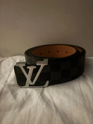 Rutigt bälte med silver spänne - Jag säljer ett helt oanvänt svart rutigt läderbälte med silver spänne. Det unika med detta bältet är den svarta färgen som kan kombineras med allt.