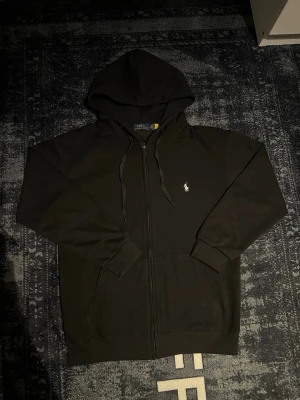 Svart Ralph lauren zip up hoodie - Helt ny aldrig använd! Prima skick!! Hör av er vid frågor och var inte rädd att lägga bud!