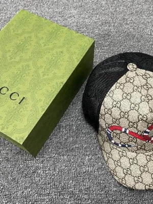 Gucci keps med orm och GG-mönster - Säljer en snygg Gucci keps i beige med klassiskt GG-mönster och en röd orm på framsidan. Kepsen har svart mesh på sidorna och baksidan för extra ventilation. Perfekt accessoar för att lyfta din outfit.