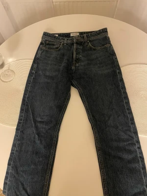Jack & Jones Loose Fit Jeans blå 29/30 - Säljer ett par mörkblå loose fit jeans från Jack & Jones, modell Loose/Chris. Klassisk femficksdesign, raka ben och normal midja. Tillverkade i slitstarkt denim med snygg tvättad look och kontrastsömmar.
