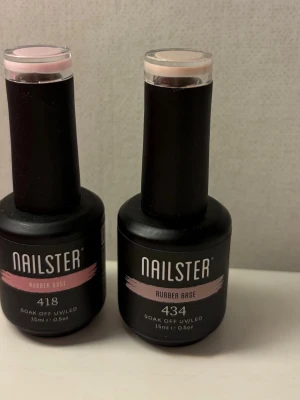 Nailster Rubber Base 418 & 434 - Två flaskor Nailster Rubber Base i nyanserna 418 och 434. Båda är soak off UV/LED-baser för naglar, 15 ml per flaska. 418 har en ljusrosa ton och 434 är mer beige-rosa. Snygga flaskor i matt svart med tydlig färgmarkering på locket. Köpte fel produkter så har endast testat dem 1 gång