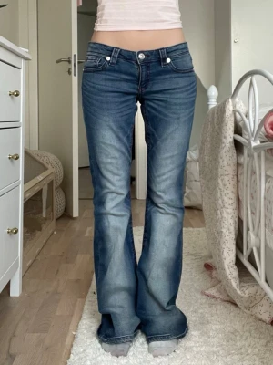 Ginatricot Young 14+ low waist bootcut jeans - Jättefina mörkblåa med röda sydda mönster från Gina 14+. Har bara använt några gånger men känner inte för att ha dom längre 💞 storlek M. Mått: • midja: 38cm • Skrev: 19cm • längd vid ben: 98/99cm • längst ner vid fötter: 24cm 