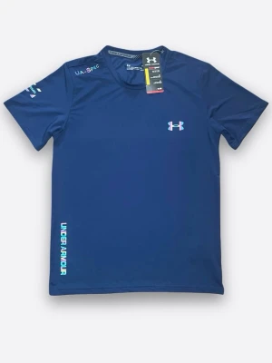 Blå träningströja från Under Armour. Finns i alla storlekar! - Sportig blå t-shirt från Under Armour med kort ärm och rund hals. Logga på bröstet och textdetaljer på ärm och nederkant i turkos och rosa. Tillverkad i ett lätt och snabbtorkande syntetmaterial, perfekt för träning.