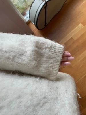 Vit fluffig stickad tröja - Mysig vit stickad tröja med fluffig yta. Passformen är loose och den är perfekt för att hålla värmen under kyliga dagar. Lite nopprig, men det är även så modellen är orginellt. Köpt för 699 och är använd men i bra skick! Pris går att diskutera💗