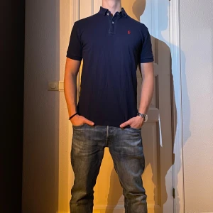 Marinblå pikétröja Polo Ralph Lauren - Marinblå pikétröja från Ralph Lauren i storlek S. Fint skick till ett bra pris. Nypris: 1595kr. Mitt pris: 299kr                  Vid frågor eller funderingar, tveka inte att höra av dig.