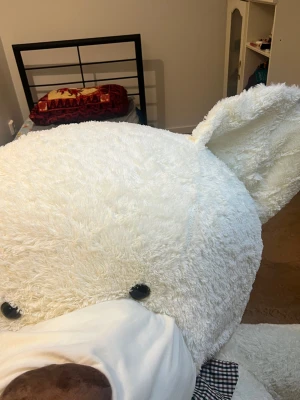 Otroligt stor och mjuk nallebjörn – helt ny! 🧸 - Denna enorma nalle på 3 meter är tillverkad i vit, mjuk plysch och är helt ny, i perfekt skick utan minsta tecken på slitage eller fläckar. Den har en charmig rosett runt halsen som gör den extra gullig och dekorativ.  En perfekt gåva eller mysig inredningsdetalj som passar både barn och vuxna som vill ha en extra stor kramkompis. Den imponerande storleken gör den till en riktig blickfångare i vilket rum som helst – från sovrum till vardagsrum eller lekplats.  Mått: 3 meter lång Skick: Helt ny