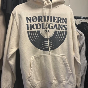 Beige hoodie Northern Hooligans - Säljer en beige hoodie från Northern Hooligans med stort print på bröstet. använd fåtal gånger