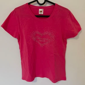 t-shirt med rhinestone-design - Lite liten i storleken så passar definitivt om man har storlek M, eventuellt lite löst passande på storlek S. Superfint tryck med stenar och inga defekter. Personen på bilden har normalt sett storlek S & M i tröja, mått finns om så önskas!