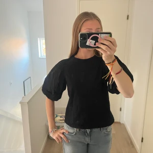 Svart topp med puffärmar från H&M - Svart topp från H&M med stora puffärmar och rund halsringning. Toppen är i mjuk bomull och har en rak passform som ger en snygg siluett. Perfekt för dig som gillar trendiga detaljer och vill sticka ut lite extra. Strl S men skulle säga att den passar Xs också💗
