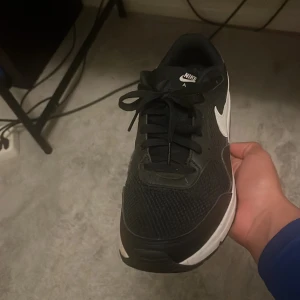 Nike Air Max svart/vit sneaker 42 - Svarta Nike Air Max sneakers med vit sula och vit swoosh på sidan. Skon har klassisk Air Max-dämpning, snörning och meshdetaljer för extra andningsförmåga. Perfekt för dig som gillar sportig och stilren look.   PRIS KAN DISKUTERAS!!
