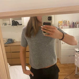 Grå stickad tröja från Zara - Mysig grå stickad tröja från Zara i storlek S. Tröjan har korta ärmar, rund hals och en enkel💕 nästan inte använd 