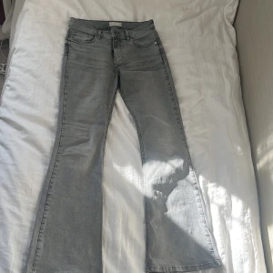Grå bootcut jeans från Perfect Jeans - Snygga grå jeans från Perfect Jeans i bootcut-modell. Jeansen har klassisk femficksdesign, normal midja och är tillverkade i mjukt denimtyg. Perfekt för dig som gillar en avslappnad men trendig look. Använda men i nyskick! Passar 36/S