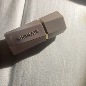 SHEGLAM Sun Sculpt Camel Suede bronzer - Säljer en SHEGLAM Sun Sculpt Liquid Contour i färgen Camel Suede. Flytande bronzer med smidig applikator, perfekt för att skulptera ansiktet. Snygg sexkantig beige förpackning med gulddetalj och logga på locket. Innehåller 7,2 ml.