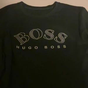 Olivgrön långärmad tröja Hugo Boss - Hej säljer den här riktigt feta olivgröna sweatshirt från Hugo Boss, den är för stor för mig så jag använder ej. Riktigt fin tröja i mitt perspektiv och det är fin färg nu inför vintern för att sticka ut lite. Förutom att den är lite sliten på ärmen så har den inga fler ”skador”. Priset kan diskuteras ! Tack!