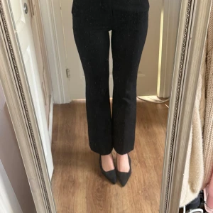 Svarta kostymbyxor från Bik Bok - Snygga svarta bootcut kostymbyxor från Bik Bok med hög midja. Byxorna har klassiska fickor fram oxh bälteshällor. .Jag är 169cm och bör storlek 36