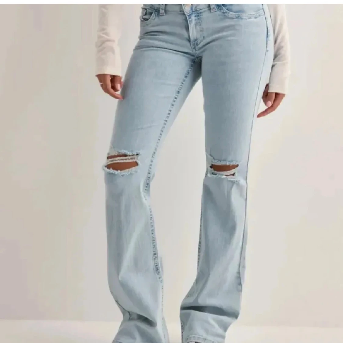 Bootcut ljusblå jeans med slitningar