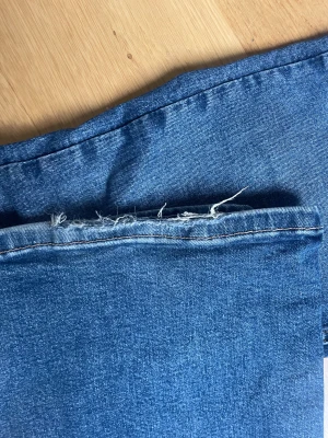 Blå bootcut jeans - Snygga blå jeans med bootcut-modell. Jeansen har klassisk femficksdesign och är tillverkade i ett mjukt denimtyg som sitter skönt på kroppen. Perfekta för dig som gillar en avslappnad men trendig look. Har slitits längst ner på byxan se bilden ☺️