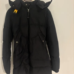 Svart lång dunjacka Parajumpers - Svart lång dunjacka från Parajumpers med huva. Perfekt för kalla dagar. Den är i storlek Toung Large men är som en vuxen S. nypris 8000kr. Priset kan diskuteras