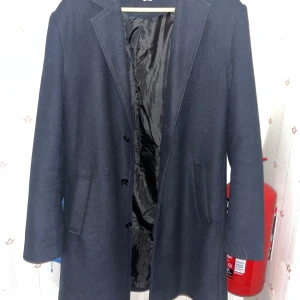 Mörkblå överrock för vinter - En fin rock i storlek M. Smal i axlarna men passar fint, skulle säga att skicket är 9/10. Använd få gånger ute och alltid upphängd på galge. PRISET GÅR ATT DISKUTERA!