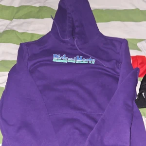 Lila Rick and Morty hoodie från H&M - Säljer en lila hoodie från H&M med Rick and Morty-tryck både fram och bak. Tröjan har huva med snörning och en stor grafisk Rick-illustration på ryggen. Regular fit och tillverkad i mjuk bomullsblandning. Perfekt för dig som älskar serien!