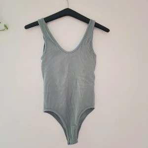 Ribbad mintgrön baddräkt från NAKD - Mint-turkos body i supermjukt tyg, lite athleisure-mjukt skulle jag säga. Står L, men jag har kunnat använda den utan att den känts för bulkig någonstans. Passar nog mellan Större S-L skulle jag säga. (Inga problem för mig som har ganska lång torso! Har alltid problem med att bodys är för korta annars) Sista bilden representerar färgen bäst