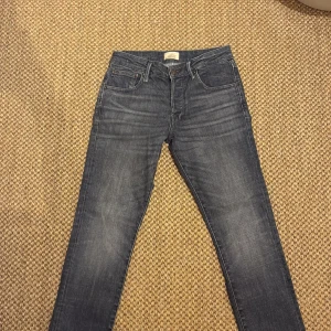 Slim straight jeans i mörkgrå denim - Slim straight jeans från Jack & Jones i en snygg mörkgrå tvätt. Klassisk femficksmodell med dragkedja och knapp för en stilren look. Perfekt passform för dig som gillar smalare ben men ändå vill ha lite rymd. Modell slim/straight Tim. Bara använda ett par fåtal gånger.