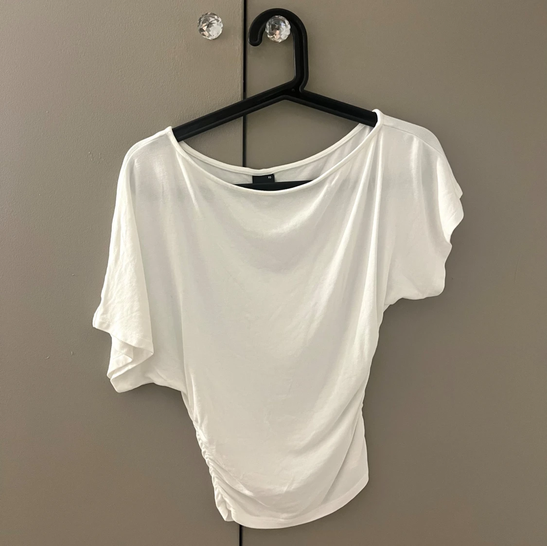 Sloped shoulder top